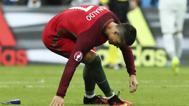 epa05419302 Cristiano Ronaldo of Portugal sits down as he is forced to pull out of the game due to injury during the UEFA EURO 2016 Final match between Portugal and France at Stade de France in Saint-Denis, France, 10 July 2016. (RESTRICTIONS APPLY: For editorial news reporting purposes only. Not used for commercial or marketing purposes without prior written approval of UEFA. Images must appear as still images and must not emulate match action video footage. Photographs published in online publications (whether via the Internet or otherwise) shall have an interval of at least 20 seconds between the posting.) EPA/MIGUEL A. LOPES EDITORIAL USE ONLY