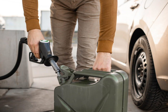 Man,Refilling,Canister,With,Fuel,On,The,Petrol,Station.,Close